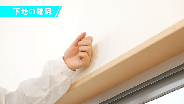 壁を軽くたたく