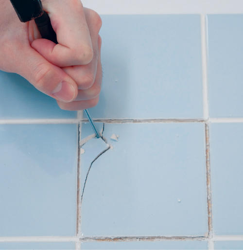 2.欠けたり、ヒビの入ったタイルは、ドライバーをのみの要領であて、金づちを使って少しずつきれいにはがします。