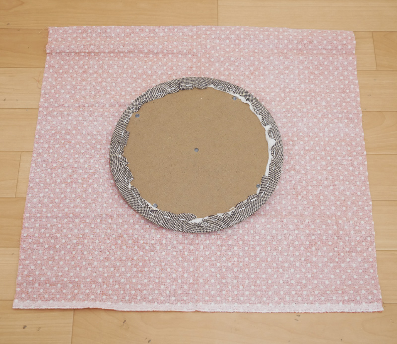 3.新しい張り地を裏返し、その上に古い張り地のままの座面を裏返して載せます。この時、繊維の方向が奥行き方向に対し斜めにならないように注意します。