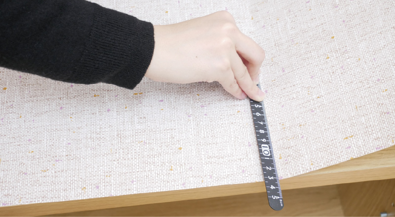 3.空気が入らないように定規などで押さえながら貼っていきます。貼る前に一部をマスキングテープで固定すると貼りやすくなります。